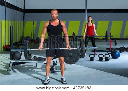 Gym-Mann und Frau mit Gewichtheben-Bar-Training in Übung
