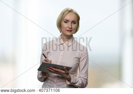 Successful Woman Is Writing Down Something On The Tablet. Beautiful Caucasian Blond Businesswoman Wi