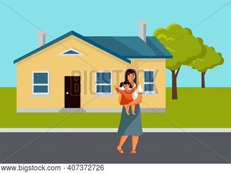 The Mother Stands With A Small Child In Her Arms. Parent And Daughter Are On The Street At The House