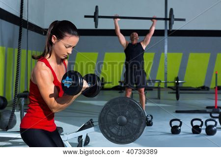 Mädchen Hantel und Mann Gewichtheben Bar Workout im Fitness-Studio
