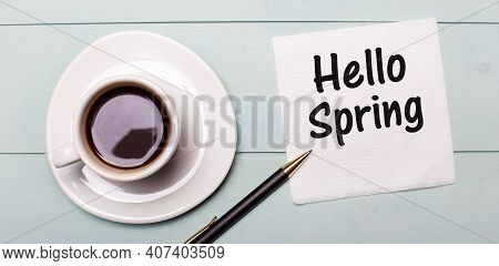 On A Light Blue Wooden Tray, There Is A White Cup Of Coffee, A Handle And A Napkin That Says Hello S