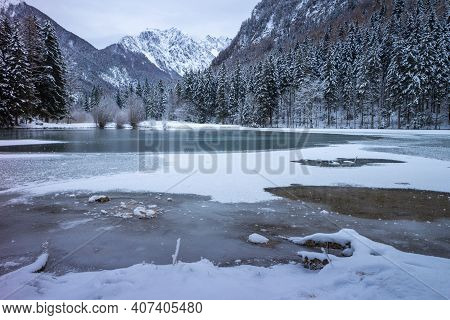 Frozen Winter Lake In The Mountains Covered With Snow. Plansar Lake, Jezersko Slovenia.