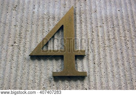 A Brass Number Four Against A  Limestone Background On The Wall Of A Building In The Centre Of Londo