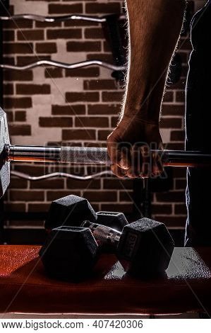 Fit And Muscular Man Doing Biceps Workouts With Dumbbells In Gym, Copy Space.