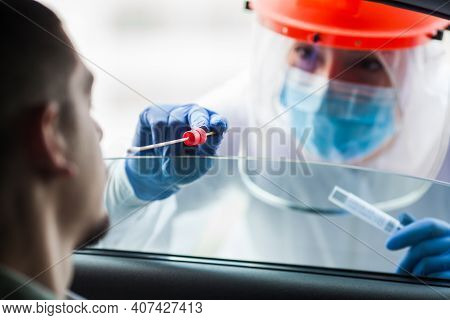 Covid-19 Drive-thru Patient Specimen Collection,female Medical Worker Performing Nasal Swab On Young