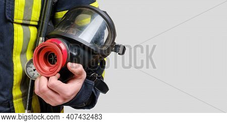 Full Protective Breathing Mask In Hand Of Unrecognized Firefighter, Rescue And Fire Fighter Equipmen