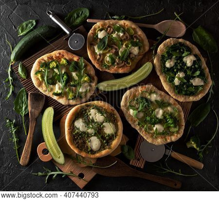 Fresh Green Pizzas On Oak Wood Cutboards With Cucumber, Vegetables, Spinach And Pizza Cutters, Woode