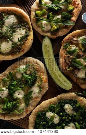 Fresh Green Pizzas On Oak Wood Cutboards With Cucumber, Vegetables, Spinach And Pizza Cutters Overhe