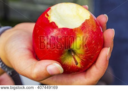 Red Bitten Off Apple In Hand In Norway.