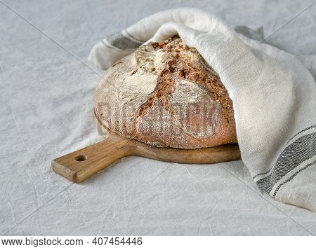 No Knead Handmade Loaf On Cutting Board On Textile With Linen Towel, Spelt Ears. German Bauernbrot M