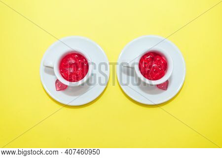 Two Cups With Hearts On A Red Background. The View From The Top. Red Hearts Spilled Out. Isolated On