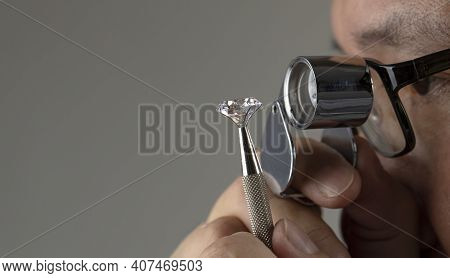 Asian Man With Glasses Diamond Dealer Buyer Expert Evaluates Polished Diamond Through Magnifying Gla