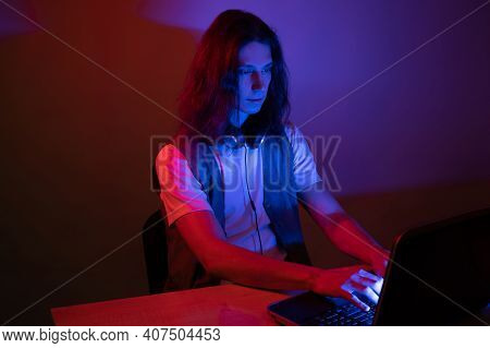 Student Or Programmer At A Laptop, Portrait In Neon Tinting. Funny Guy Geek Writes Code.