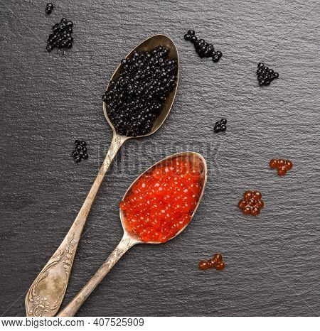 Black Caviar Of Paddlefish Fish And Red Chum Salmon Caviar In A Spoon, Black Background, Top View
