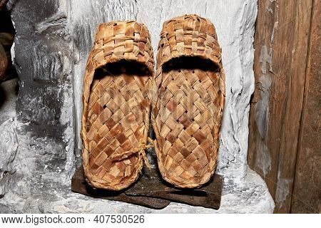 Old Bast Shoes Are Dried On A Stone Stove In An Old Village Hut.
