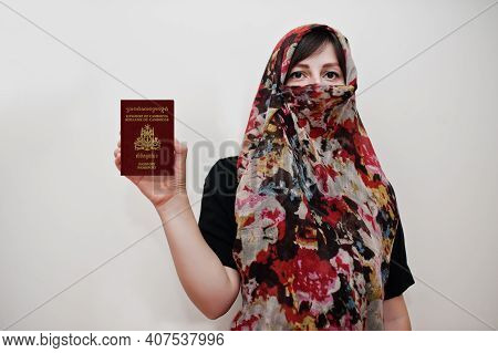 Young Arabian Muslim Woman In Hijab Clothes Hold Kingdom Of Cambodia Passport On White Wall Backgrou