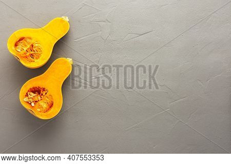 Raw Organic Butternut Pumpkin Or Gramma Cut In Half Close-up On Gray Concrete Background, Top View, 
