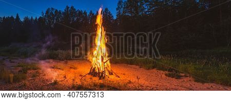 Landscape Of Forest At White Night. Close-up Of Huge Fire. Traditional Midsummer Ligo Celebration. P