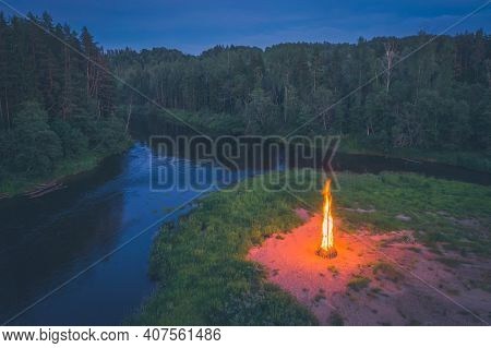 Landscape Of Forest And River At White Night. Huge Fire. View From Above. Midsummer Ligo Celebration