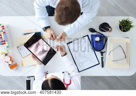 Doctor Showing Patient Xray On Tablet Top View. Diagnosis Of Lung Diseases Concept