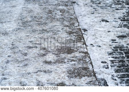 De-icing Chemicals On The Pavement. Pavement Is Sprinkled With Technical Salt Or Salt Mixtures Based