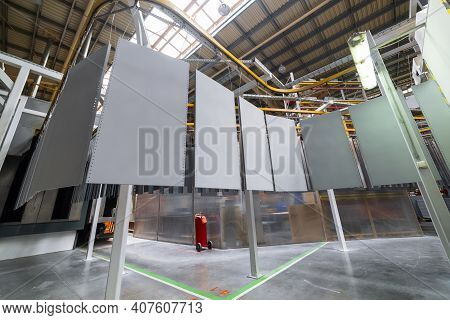 Powder Coating Line. Metal Panels Are Suspended On An Overhead Conveyor Line. Painting Products In A