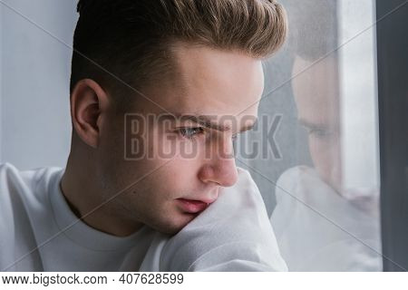 Handsome, Sad Lonely Teenager, Young Guy Looks Out The Window