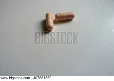Group Of Two Pink Capsules Of Probiotic Dietary Supplement