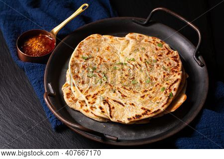 Food Concept Spot Focus Homemade Paratha, Parotta Or Porotta Layered Flatbread  On Black Background