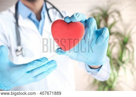 Doctor Hand In Latex Gloves Holding Red Heart Close Up