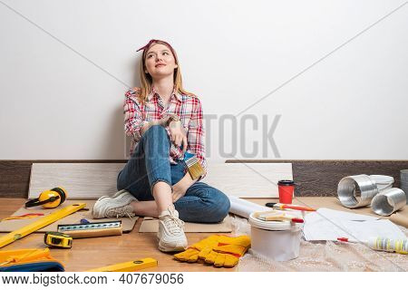 Dreamy Beautiful Girl Painter Sitting On Floor With Brush. Home Remodeling And House Interior Redesi