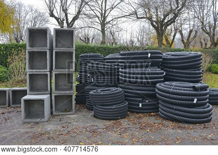 Reinforced Concrete Square Box Culverts And Rolls Of Black Corrugated Flexible Drain Pipes On A Cons