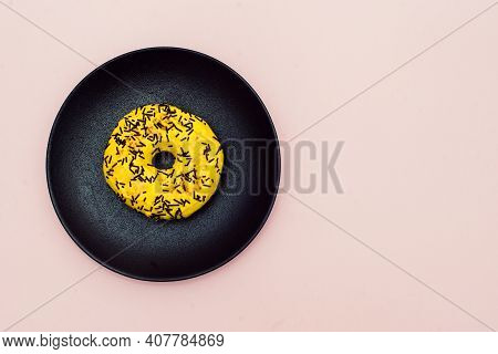 Yellow Donut Decorated With Chocolate Sprinkles Isolated On Pink Background. Top View. Left Side. Sp