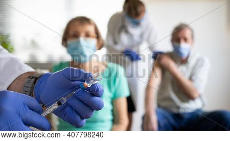 medical team giving coronavirus vaccine to seniors in vaccination center