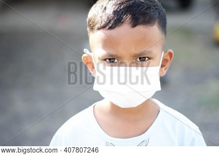 Asia Boy Wearing Facial Mask For Protect Corona Virus And Air Pollution Pm2.5 With Blurred Backgroun