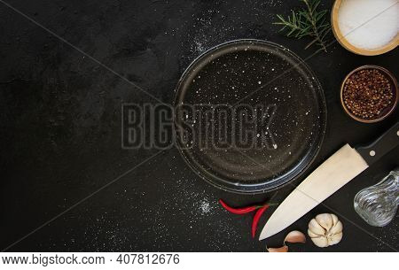 Empty Black Plate On A Dark Metal Background. Top View With Copy Space.