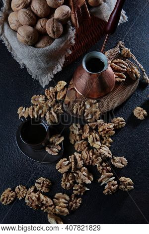 Peeled Walnuts On A Dark Background. Coffee In A Copper Turk. The Kernel Of A Walnut. Wooden Board.