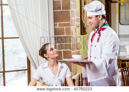 Chef bringt eine SchÃ¼ssel hÃ¼bsche Frau in einem restaurant