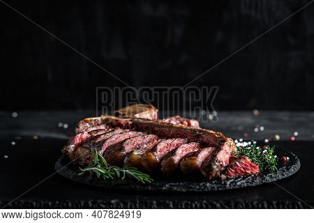 Traditional American Barbecue Dry Aged Steak Sliced. Porterhouse Steak Sliced As Top View On A Slate