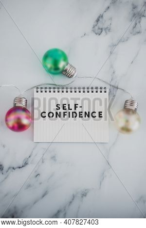 Positive Attitude Concept, Self--confidence Text On Notepad Surrounded By Light Bulbs