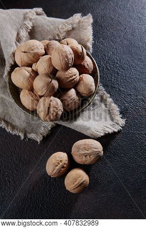 Walnuts On A Cotton Napkin On A Dark Background. Whole Walnuts. Natural Bio Product. Vertical Photo.