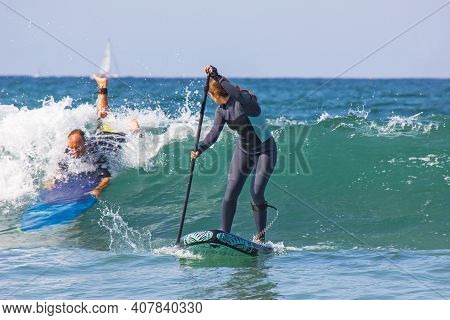 09-12-2020, Hendaya, France.young Woman With Wetsuit On An Inflatable Paddle Sup Surfboard Preparing