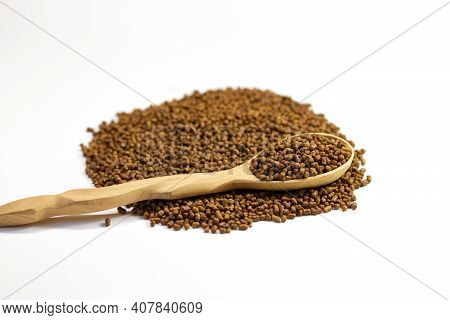 Buckwheat Tea In A Wooden Spoon On A White Background. Isolate. Buckwheat Tea Close-up Macro Photogr