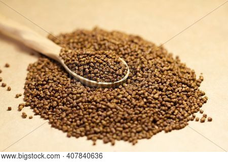Buckwheat Tea In A Wooden Spoon On A Brown Background. Buckwheat Tea Close-up Macro Photography. Sca