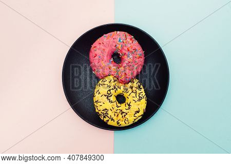Colored Donuts With Colorful Sprinkles On Pink And Blue Background. National Pink Day Or Doughnut Da