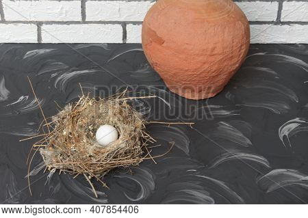 Small Bird's Nest With White Egg On Dark Vintage Table. Close-up. Procreation Concept, Happy Easter.