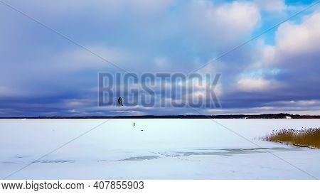 Panorama Of Snowy Lake With Lonely Sportsman Doing Winter Kiting In Riga, Latvia