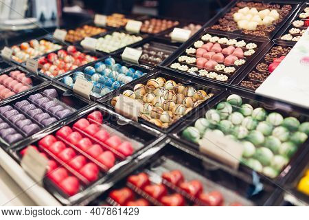 Assortment Of Chocolate Colorful Candies Desserts On Cafe Showcase. Variety Of Sweets With Different