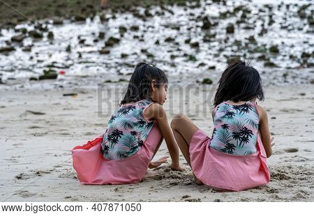 Two Little Kids Making Sand Castle And Playing At Tropical Beach. Little Girls Back View While Playi