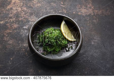 A Goma Wakame, Top View, On A Black Stony Background. A Pickled Seaweed Japanese Salad.